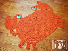 an orange crab rug with blue eyes on the floor