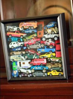 there are many toy cars in the shadow box