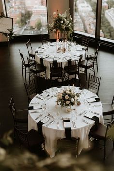 the tables are set with white tablecloths and black chairs