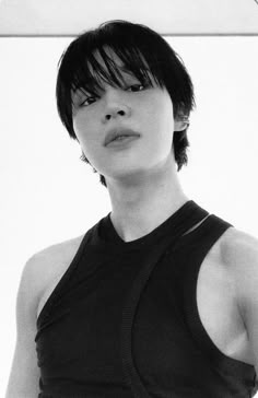 a black and white photo of a woman with short hair wearing a sleeveless top