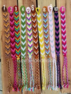 several different colored chevroned bracelets are lined up on a wooden board with numbers