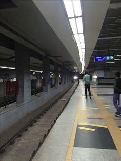 two people are standing at the train station