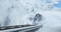 a train traveling down tracks next to snow covered mountains and clouds in the sky,