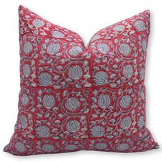 a red and grey pillow with paisley print on the front, sitting on a white surface