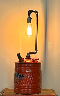 an old fashioned light bulb sitting on top of a barrel filled with oranges and other items