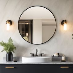 a bathroom vanity with a round mirror above it and a potted plant on the counter