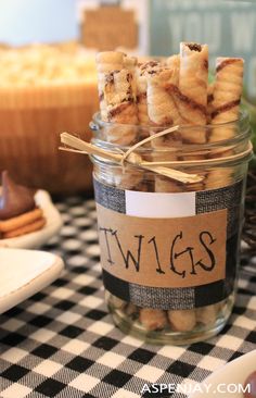 a jar filled with cookies sitting on top of a checkered tablecloth covered table