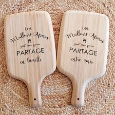 two wooden paddles sitting on top of a straw mat with writing that says,'les malles de paris & marriage parfage en fancile '