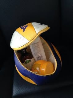 a yellow and blue hat sitting on top of a car seat next to other items