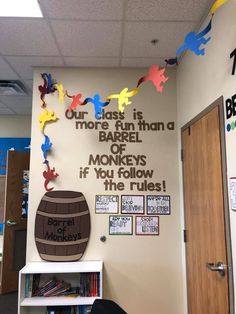 an office decorated with colorful paper birds and a sign that reads our class is more fun than barrel of monkeys if you follow the rules