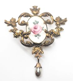 Guillouche pink rose flower white enamel Art Nouveau style faux pearl vintage brooch. Fair vintage condition with small signs of normal vintage wear. Enamel is smooth with no signs of crazing or chips. There is a small amount of discoloration under the seal around the edge as seen in pictures. Small amount of wear on the surface of one pearl accent.  Brooch measures 2 and 1/4 of an inch tall and 2 inches wide. Vintage Rose Gold Brooches For Wedding, Vintage Rose Gold Wedding Brooches, Vintage Rose Flower Brooch, Vintage Rose Brooch Jewelry, Vintage Rose Jewelry With Brooch, Vintage Pink Enamel Brooches, Vintage Rose Brooch, Vintage Rose-colored Flower-shaped Jewelry, Vintage Rose Flower Jewelry