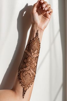 a woman's arm with a henna tattoo on it