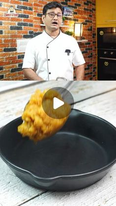 a man standing in front of a frying pan with food on top of it