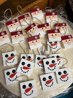 snowmen and santa hats made out of popsicle sticks on a table with plastic bags