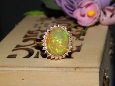 All Opals Are 100% Natural And Certified. Item details Sourced, Designed and Made BY Art Palace by MITIKA. Stone(s) : Natural Fire Opal  Total Weight : 3.92 Grams Material 925 Sterling Silver/14K Gold Silver/Gold Weight : 2.76 Grams MAIN STONE INFORMATION Stone weight : 5.40 ct. Size : 12x14 mm Shape : Oval Setting TypeProng Number Of Stones : 1 SIDE STONE INFORMATION Stone : Natural Diamond Weight : 0.38 ct. Shape : Round Number Of Stones : 24 Custom Order-------    We can craft this ring in 92 Diamond Opal Ring Gift, Gold Opal Ring With Center Stone As Gift, Fine Jewelry Opal Ring With Halo Setting As Gift, Luxury Opal Halo Ring Gift, Luxury Opal Ring With Halo For Gift, Luxury Halo Opal Ring For Gift, Luxury Opal Ring With Halo As Gift, Oval Cluster Ring With 17 Jewels As Gift, Gold Ring Diamond