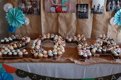 a table topped with lots of cupcakes covered in frosting