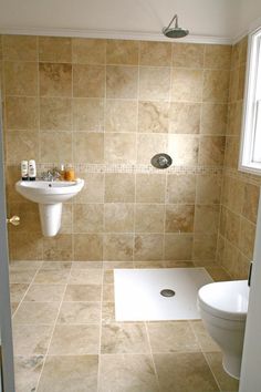 a bathroom with a toilet, sink and shower stall in it's own area