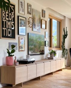 a living room filled with furniture and lots of framed pictures on the wall above it