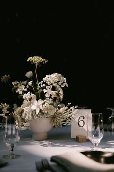 the table is set with flowers and wine glasses