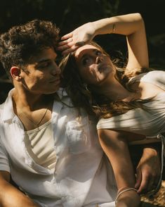 a man and woman sitting next to each other with their hands on their foreheads