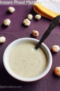 there is a bowl of soup with a spoon in it on the table next to some nuts