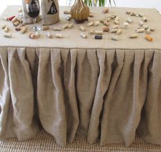 a table topped with vases and rocks on top of a cloth covered tablecloth