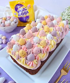 a white plate topped with a cake covered in easter eggs and marshmallows