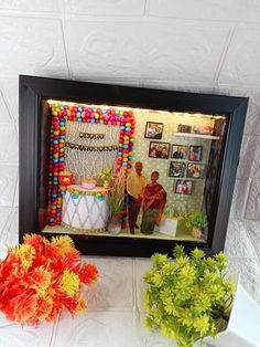 two vases filled with flowers sitting on top of a table next to a wall