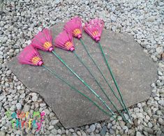 five pink umbrellas sitting on top of a rock in the middle of some rocks