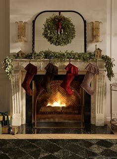 stockings hanging from the fireplace in front of a wreath