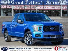 a blue truck is parked in front of a ford dealership with the words good fellow's auto written on it