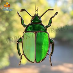 a green glass bug hanging from a window