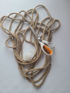 a pair of scissors sitting on top of rope