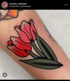 a close up of a person's leg with tattoos on it and some flowers