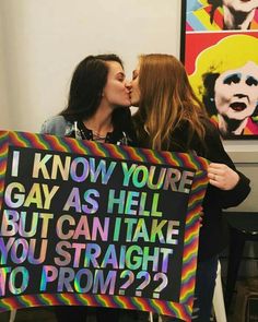 two women standing next to each other holding a sign that says, i know you're gay as hell but can take you straight no from?