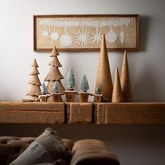 christmas trees are sitting on top of a mantle