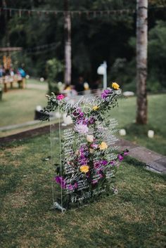 a sign that has flowers on it in the grass