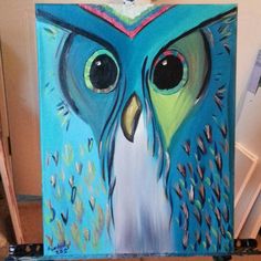 an owl painting is displayed on a easel