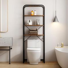 a white toilet sitting next to a bath tub under a bathroom mirror on top of a wooden shelf