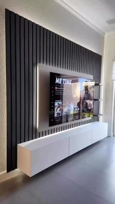 a flat screen tv mounted to the side of a wall in a room with black and white stripes