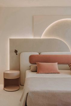 a white bed with pink pillows in a bedroom