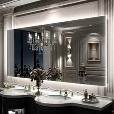 a bathroom with two sinks and a chandelier in the mirror over it's windows