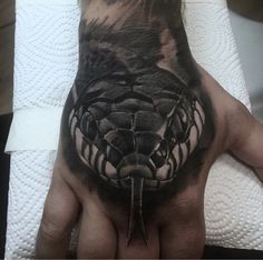 a person's hand with a black and white tattoo design on the middle of it