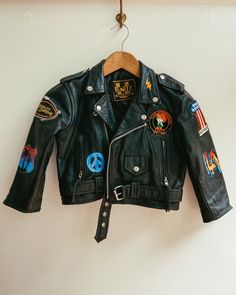 "One-of-a-kind vintage leather biker jacket with original Harley Davidson patches and hand-painted elements that add to the uniqueness of this truly rare piece. Leather is in exceptional vintage condition. Brand: Unik Made in Pakistan Size: XL 100% genuine vintage leather Hand-painted with Angelus Leather Paint and signed by the artist MEASUREMENTS Shoulder: 14.5\" Bodice length: 15\" Arm length: 15\" Chest: 17\" (across front, laying flat)" Graphic Print Outerwear For Fall Biker Events, Graphic Print Outerwear For Biker Events In Fall, Winter Leather Jacket With Graphic Print For Biker Events, Edgy Graphic Print Biker Jacket For Biker Events, Black Biker Jacket With Graphic Print, Edgy Biker Jacket With Graphic Print For Biker Events, Edgy Graphic Print Biker Jacket For Events, Fall Graphic Print Biker Jacket For Biker Events, Biker Leather Jacket With Graphic Print For Streetwear