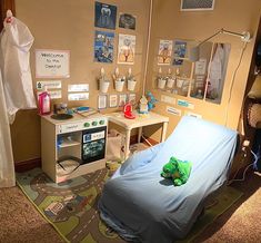 a child's hospital room with a bed, desk and other medical supplies on display