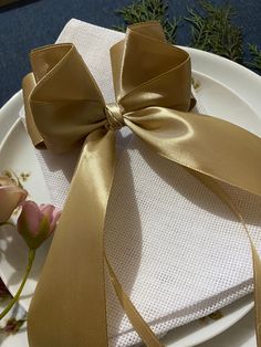 a white plate topped with a napkin and a gold bow