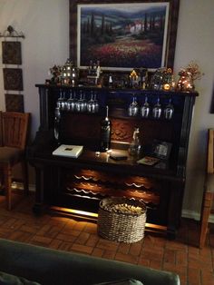 a living room filled with furniture and a painting on the wall above it's wine rack