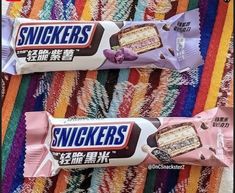 two packets of snickkers are sitting on a colorful blanket with the same package