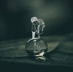 an image of a couple kissing in a glass vase on top of a wooden table