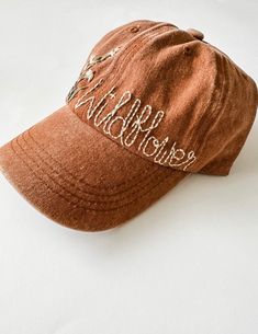 a brown hat with white writing on it